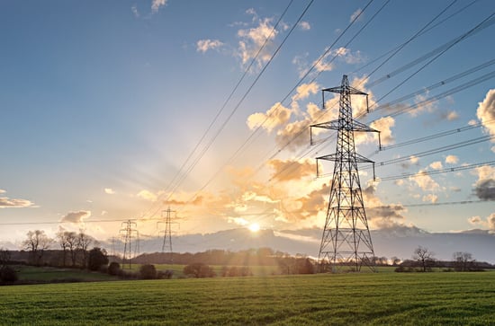 power lines in the sun light on a grassy field
