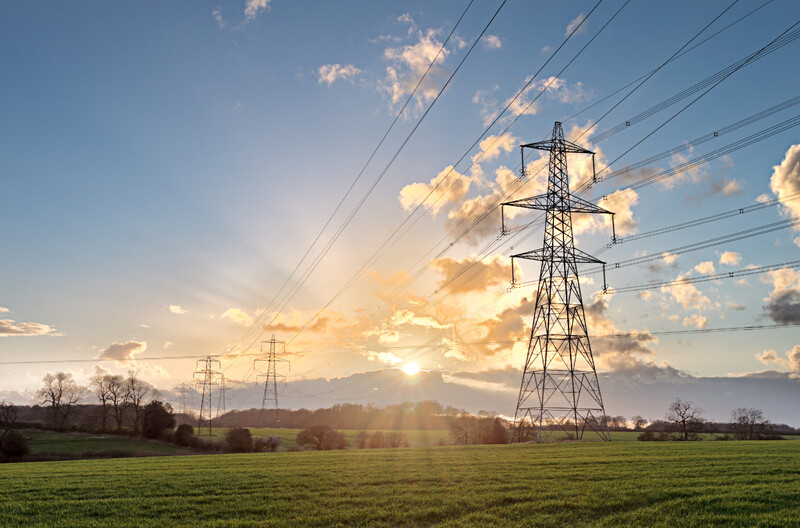 power lines in the sun light on a grassy field power lines in the sun light on a grassy field