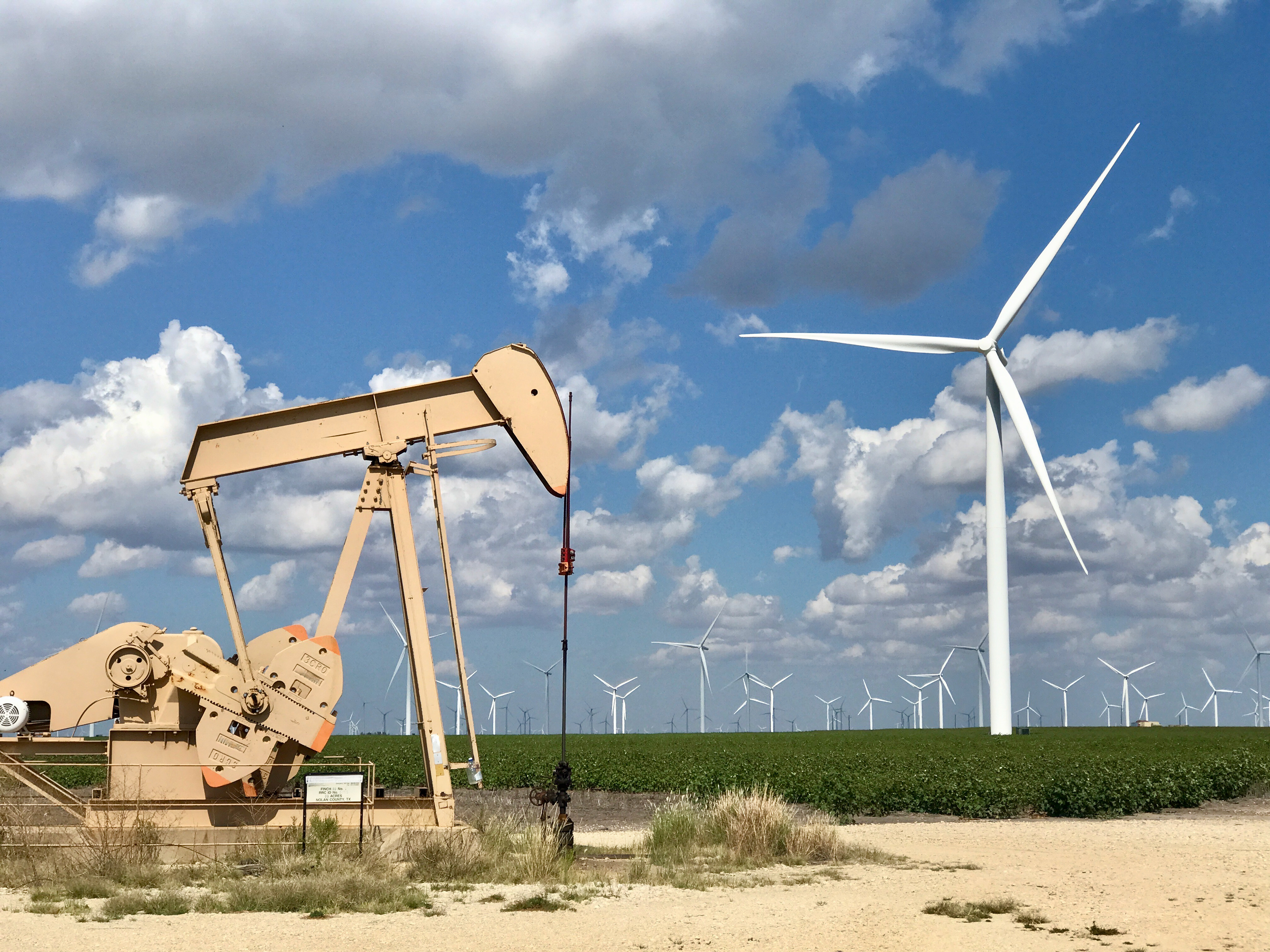 Oil Drill next to wind turbines_AdobeStock_468810913