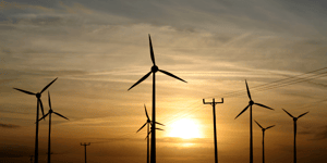 wind turbines against a sunset