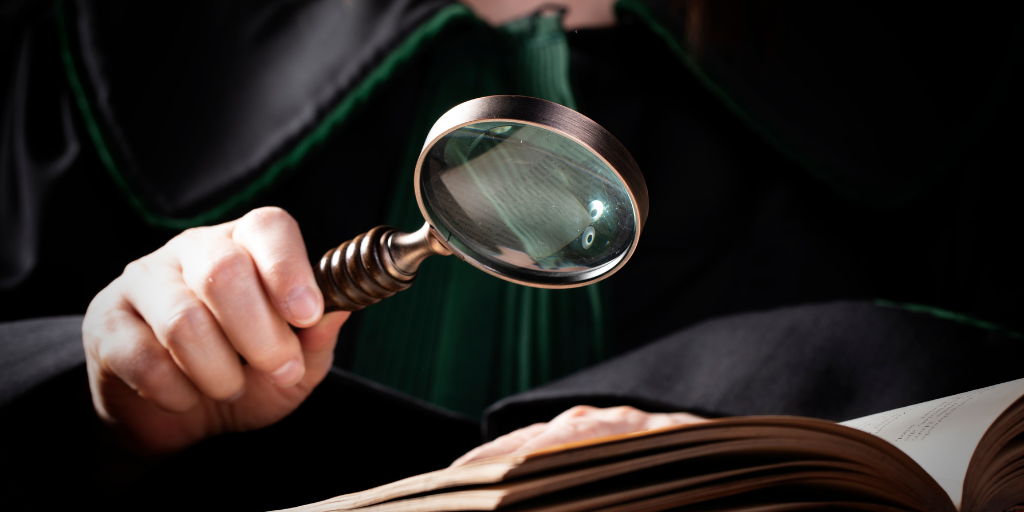 person holding a magnifying glass over a book