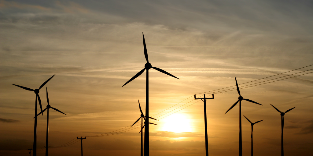 wind turbines against a sunset